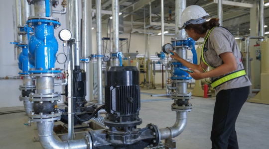 Engineer inspecting a dial on an industrial machine